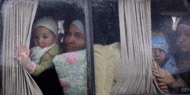 Dec. 20, 2012: Syrian refugees, who fled their home in Idlib due to a government airstrike, look out of a vehicle window just after crossing the border from Syria to Turkey.