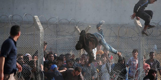 June 14: Syrian refugees cross into Turkey from Syria over and through a hole on the border fence in southeastern Turkey.