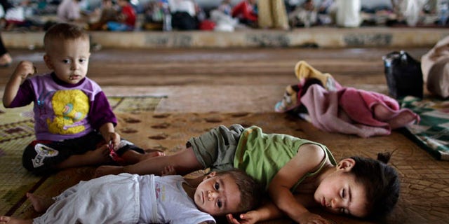 Aug. 26, 2012: Syrian children who fled their home lie on the ground while they and others take refuge at the Bab Al-Salameh border.