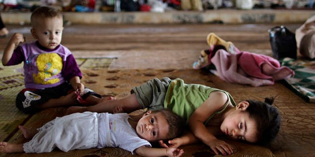 Aug. 26, 2012: Syrian children who fled their home lie on the ground while they and others take refuge at the Bab Al-Salameh border.