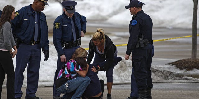 March 11, 2014: Skye Cieszlak, girlfriend of missing Saginaw Spirit hockey player Terry Trafford, is comforted after collapsing in the parking lot of the Saginaw Township Wal-Mart. Police found Trafford's body in an SUV in the parking lot (AP Photo/The Saginaw News, Neil Barris)