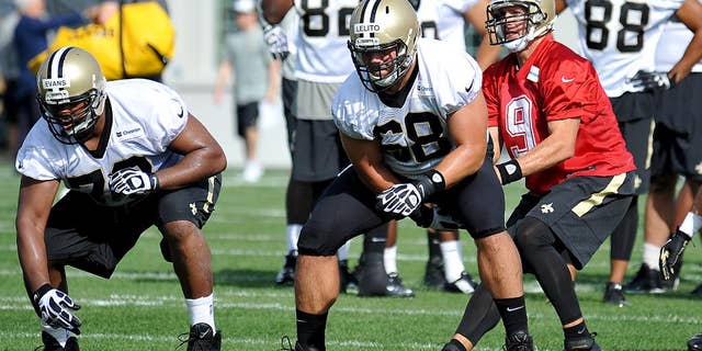 FILE - In this July 25, 2014, file photo, New Orleans Saints quarterback Drew Brees (9) takes a snap from center Tim Lelito (68) during NFL football training camp in White Sulphur Springs, W.Va. Lelito, a second-year pro, filled in for injured starter Jonathan Goodwin in the second half of their week 3 victory over Minnesota. (AP Photo/Chris Tilley, File)