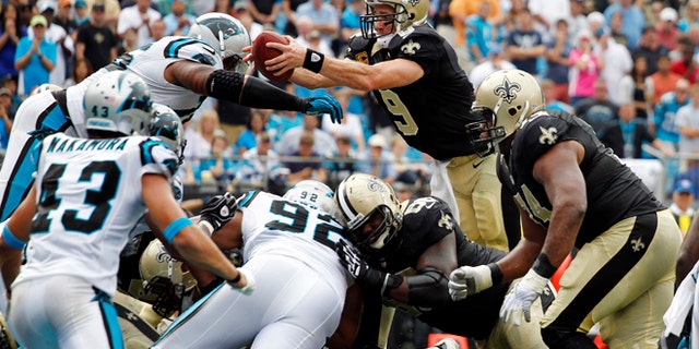 Sept. 16, 2012: New Orleans Saints' Drew Brees (9) reaches the ball over the goal line for a touchdown against the Carolina Panthers during the fourth quarter of an NFL football game in Charlotte, N.C. The Panthers won 35-27.