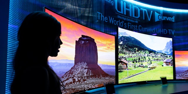 Jan. 5, 2014: A model stands next to a display of Samsung's curved 4K UHD TVs during a preview event at the International Consumer Electronics Show in Las Vegas.