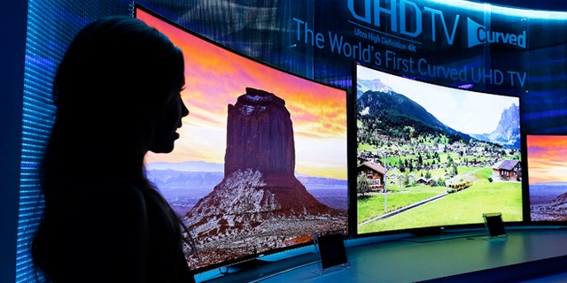Jan. 5, 2014: A model stands next to a display of Samsung's curved 4K UHD TVs during a preview event at the International Consumer Electronics Show in Las Vegas.