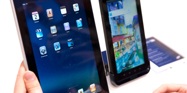 A journalist compares the new Samsung Galaxy Tab, right, a tablet computer to compete with the Apple iPad, left, at IFA, the world's largest trade fair for consumer electronics and electrical home appliances, in Berlin, Germany, Thursday, Sept. 2, 2010. IFA takes place from Sept. 3 to Sept. 8, 2010 on the Berlin Exhibition Grounds.