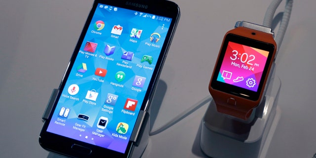 A Samsung Galaxy S5 smartphone, left, and a Samsung Gear 2 are displayed at the Samsung Galaxy Studio, in New York, Monday, Feb. 24, 2014. Samsung on Monday unveiled a new smartphone with a built-in heart rate monitor to complement three upcoming fitness devices, as the Korean company tries to turn its technological wizardry into lifestyle products. (AP Photo/Richard Drew)