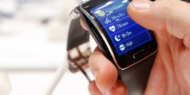 A visitor holds a Samsung Gear S smartwatch at the IFA consumer technology fair in Berlin, September 5, 2014.