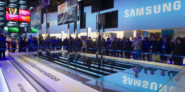 File photo - Showgoers watch a display of Samsung Smart TVs during the first day of the Consumer Electronics Show (CES) in Las Vegas Jan. 8, 2013.