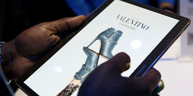 A member of the media scrolls through a fashion magazine during the debut of the Samsung Galaxy Tab S after the product's press debut in New York, Thursday, June 12, 2014.
