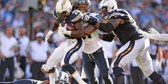 Aug 29, 2015; San Diego, CA, USA; San Diego Chargers running back Melvin Gordon (28) is tackled by Seattle Seahawks middle linebacker Bobby Wagner (54) and outside linebacker Bruce Irvin (51) during the first quarter as tackle King Dunlap (77) attempts to help at Qualcomm Stadium. Mandatory Credit: Jake Roth-USA TODAY Sports