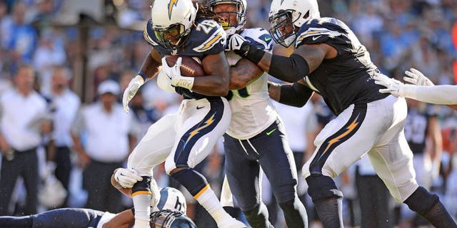 Aug 29, 2015; San Diego, CA, USA; San Diego Chargers running back Melvin Gordon (28) is tackled by Seattle Seahawks middle linebacker Bobby Wagner (54) and outside linebacker Bruce Irvin (51) during the first quarter as tackle King Dunlap (77) attempts to help at Qualcomm Stadium. Mandatory Credit: Jake Roth-USA TODAY Sports