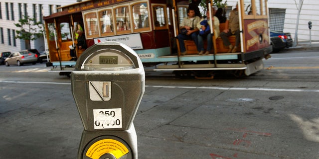 FILE - In this Oct. 27, 2009 file photo, a cable car passes a parking meter near San Francisco's financial district. (AP Photo/Ben Margot, File)