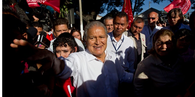 FILE - In this Feb. 2, 2014 file photo, Vice President Salvador Sánchez Cerén, presidential candidate for the ruling Farabundo Marti National Liberation Front (FMLN), greets supporters after voting at a polling station in San Salvador, El Salvador. Sanchez, a former guerrilla commander, is the favorite to win the second round presidential election Sunday, March 9, 2014. (AP Photo/Esteban Felix, File)