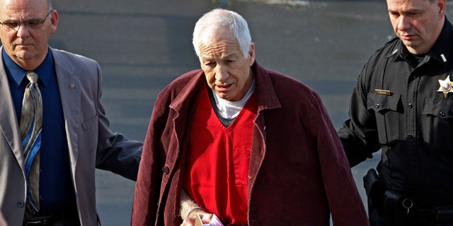 Jan. 10, 2013: Former Penn State University assistant football coach Jerry Sandusky, center, leaves the Centre County Courthouse after attending a post-sentence motion hearing in Bellefonte, Pa.