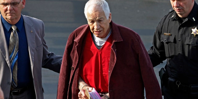 Jan. 10, 2013: Former Penn State University assistant football coach Jerry Sandusky, center, leaves the Centre County Courthouse after attending a post-sentence motion hearing in Bellefonte, Pa.