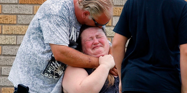 A man hugs a woman outside the Alamo Gym where parents wait to reunite with their children following a shooting at Santa Fe High School in Santa Fe, Texas, on Friday, May 18, 2018.