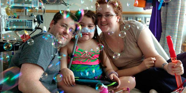 In this file photo provided by the Murnaghan family, Sarah Murnaghan, center, celebrates the 100th day of her stay in Children's Hospital of Philadelphia with her father, Fran, left, and mother, Janet.