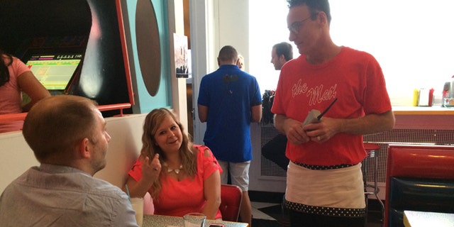 In this Wednesday, June 1, 2016 photo, original "Saved by the Bell" castmember Ed Alonzo, right, talks to Steve Gross and Tiffany Gross at pop-up restaurant Saved by the Max in Chicago. A vacant restaurant space in Chicagoâs Wicker Park neighborhood has become a replica of The Max, the fictitious hangout from the TV sitcom "Saved by the Bell." (AP Photo/Terry Tang)