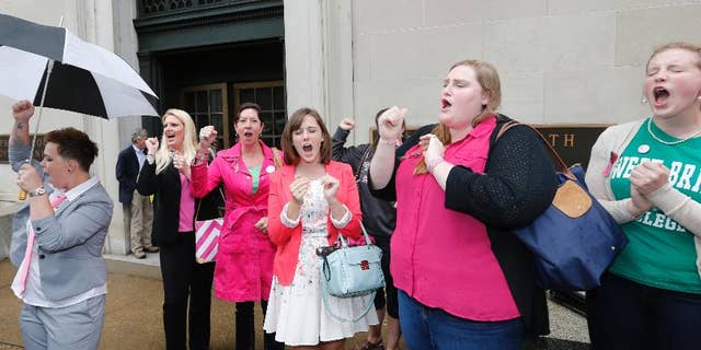 FILE - In a Thursday, June 4, 2015 file photo, Sweet Briar College alumni do a cheer for the school after a hearing on the closure of Sweet Briar college at the Supreme Court of Virginia in Richmond, Va. Sweet Briar President Phillip C. Stone marvels at the energy of passionate alumnae who helped save the school just a few months ago from closure. But he knows without a serious change in fortune, the salvation will only be temporary. (AP Photo/Steve Helber, File)