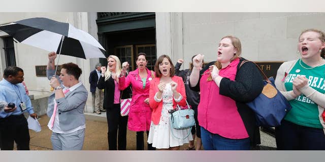 FILE - In a Thursday, June 4, 2015 file photo, Sweet Briar College alumni do a cheer for the school after a hearing on the closure of Sweet Briar college at the Supreme Court of Virginia in Richmond, Va. Sweet Briar President Phillip C. Stone marvels at the energy of passionate alumnae who helped save the school just a few months ago from closure. But he knows without a serious change in fortune, the salvation will only be temporary. (AP Photo/Steve Helber, File)