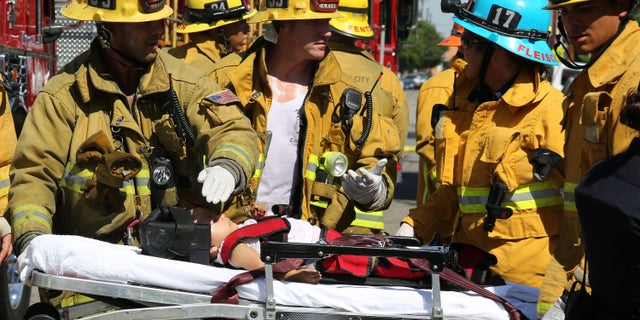 Aug. 29, 2012: Los Angeles City Firefighter paramedics assist a child, one of eight people injured when a car sped onto a sidewalk and plowed into a group of parents and children outside Main Street Elementary school in Los Angeles.