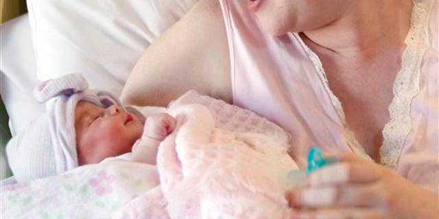 A mother holds her newborn baby.