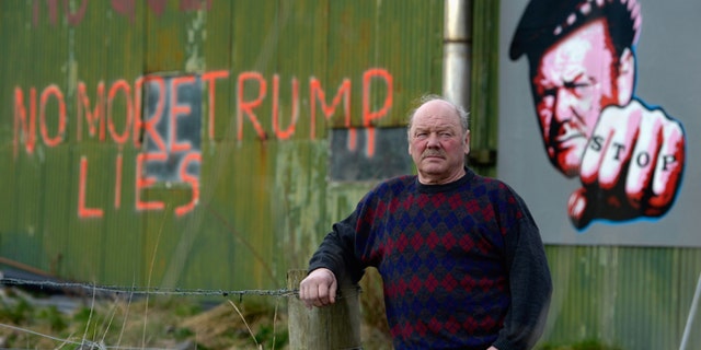 Michael Forbes stands beside his shed, near Donald Trump's golf course.