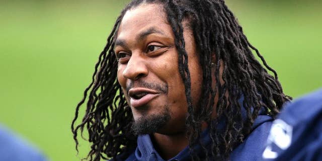 FILE - In this June 17, 2014 file photo, Seattle Seahawks' Marshawn Lynch smiles at a football minicamp practice that he watched from the sidelines in Renton, Wash. Lynch has been the workhorse Seattle has leaned on the past three seasons. He’s helped bring the team its first Super Bowl title and despite his quirks has wide-ranging respect in the locker room. (AP Photo/Elaine Thompson, File)