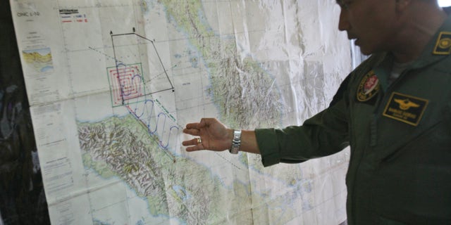 Lt. Col Bambang Sudewo, commander of the 5th Air Squadron "Black Mermaids" examines a map following a search operation for the missing Malaysia Airlines Boeing 777 that was conducted over the Strait of Malacca, at Suwondo air base in Medan, North Sumatra, Indonesia, Friday, March 14, 2014. The jetliner vanished nearly a week ago with 239 people aboard. (AP Photo/Binsar Bakkara)