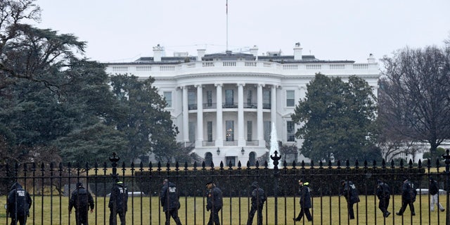 FILE - In this Jan. 26, 2015 file photo, Secret Service officers search the south grounds of the White House in Washington after an unmanned aerial drone was found on the White House grounds during the middle of the night. (AP Photo/Susan Walsh, File)