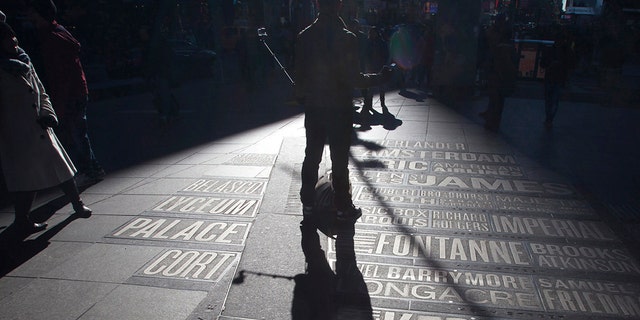 A man uses a selfie stick to take his own photos in Times Square in the Manhattan borough of New York Jan.17, 2015.