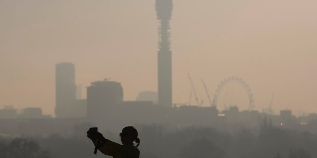 File photo. A woman takes a "selfie" photograph on a frosty morning in Primrose Hill north in London December 30, 2014.