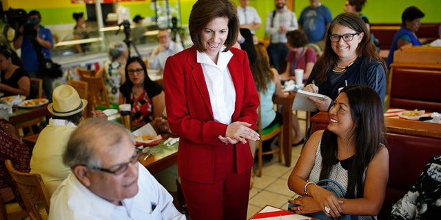 In this May 31, 2016, photo, U.S. Senate candidate Catherine Cortez Masto, center, laughs while speaking with people at a campaign event at a restaurant in Las Vegas. A battle royal is shaping up in Nevada over the open Senate seat created by the retirement of Minority Leader Harry Reid of Nevada. A former state attorney general, Masto, would be the first Latina ever to serve in the U.S. Senate. (AP Photo/John Locher)