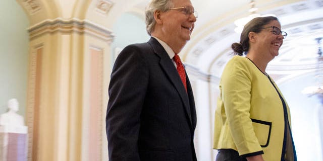 July 26, 2015: Senate Majority Leader Mitch McConnell, R-Ky., left, accompanied by Secretary for the Majority of the Senate Laura Dove, heads into the Senate chamber as the Senate convenes for a Sunday session on Capitol Hill in Washington. (AP Photo/Andrew Harnik)