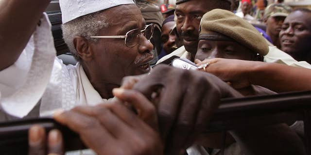 FILE - In this Friday, Nov. 25, 2005 file photo, former Chad dictator Hissene Habre, left, leaves a court in Dakar, Senegal. A former president of Chad accused of overseeing the deaths of thousands during his time in power will soon stand trial in Senegal on charges including war crimes and torture. The Extraordinary African Chambers, a special tribunal created to try ex-Chad dictator Hissene Habre, made the announcement Friday, Feb. 13, 2015 in response to the findings of a 19-month investigation into alleged crimes committed during his presidency. (AP Photo/Schalk van Zuydam, File)