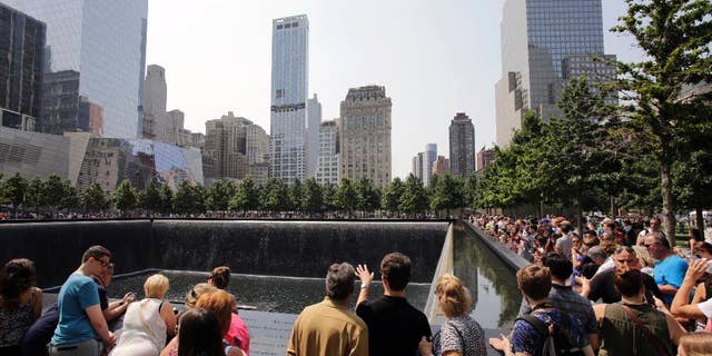 FILE - In this Aug. 8, 2014 file photo, visitors to the Sept. 11 memorial view one of the two reflecting pools in New York. A tourist from Texas was arrested on Saturday Aug. 1, 2015 on charges she was packing two loaded handguns at the Sept. 11 memorial in New York City, authorities said. According to a criminal complaint, Elizabeth Enderli was visiting the site when she informed a police officer she had the weapons in her backpack. She was charged with criminal possession of a weapon before being released Sunday. Acording to friends, the 31-year-old military veteran has a permit to carry weapons in her home state and mistakenly believed the permit covered her visit to New York from the Houston area. (AP Photo/Mark Lennihan, File)