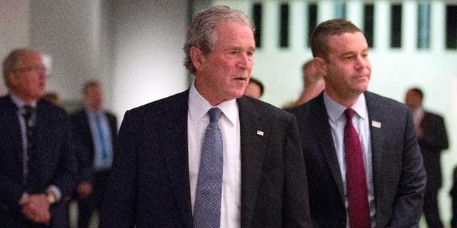 In this photo taken on Sunday, Dec. 14, 2014, and provided by the National September 11 Memorial and Museum, former President George W. Bush, center, makes an unannounced visit to the National September 11 Memorial &amp; Museum in New York. At right is National September 11 Memorial &amp; Museum President Joe Daniels.