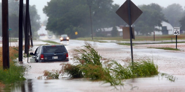 June 18, 2015: A vehicle is pointed the wrong direction after high water pushed it into a ditch on the south side of Hardesty Road west of US 177 in Shawnee, Okla. (Jim Beckel/The Oklahoman via AP)