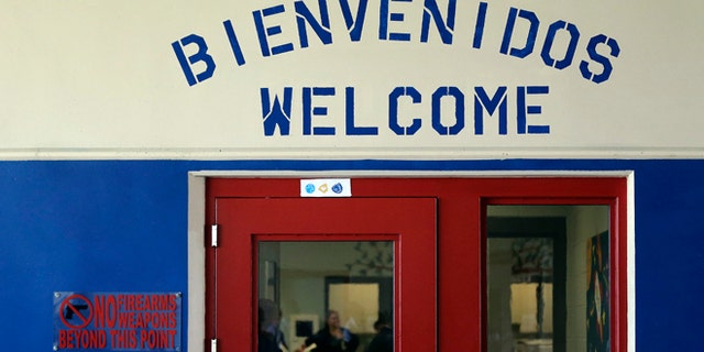File - In this July 31, 2014 file photo, a Spanish and English welcome sign is seen above a door in a secured entrance area at the Karnes County Residential Center in Karnes City, Texas, one of two family detention centers that are applying for residential child care licenses. (AP Photo/Eric Gay, File)