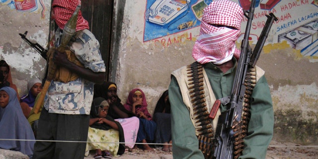 Dec. 18, 2008: Somali al-Shabaab fighters stand stand guard during a public flogging by the hardline Islamic group in Bula Marer town.