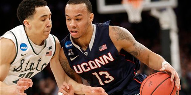 Connecticut's Shabazz Napier, right, moves the ball around Michigan State's Travis Trice in the first half of a regional final at the NCAA college basketball tournament on Sunday, March 30, 2014, in New York. (AP Photo/Seth Wenig)