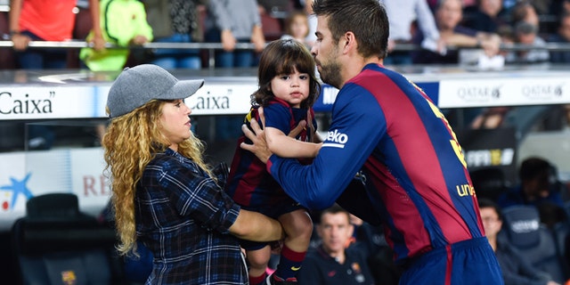 BARCELONA, SPAIN - OCTOBER 18: Gerard Pique of FC Barcelona passes his son Milan to his wife Shakira during the La Liga match between FC Barcelona and SD Eibar at Camp Nou on October 18, 2014 in Barcelona, Spain. (Photo by David Ramos/Getty Images)