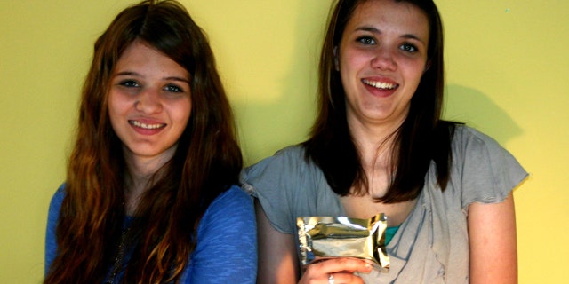 Shannon and Mikayla Diesch hold the STEM bar, a NASA-certified alternative to standard astronaut food that will accompany the crew on Endeavour's last flight.