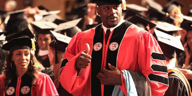 May 5, 2012: Towering over his classmates, former NBA star Shaquille O'Neal, gestures before the graduation ceremony at the James L. Knight Center in Miami.