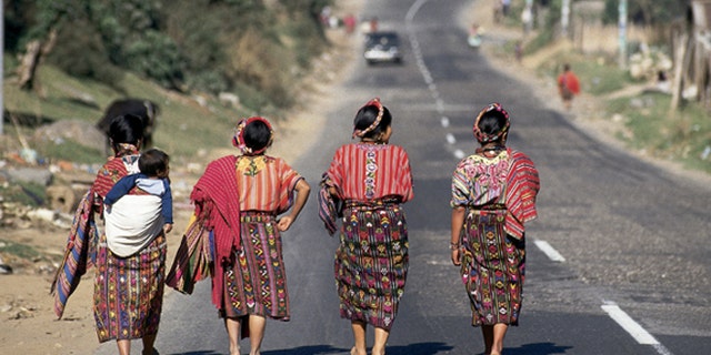 Four Guatemalan women walking down a paved highway near Cantel, Guatemala. (Photo by Independent Picture Service/UIG via Getty Images)