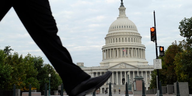 FILE - In this Tuesday, Oct. 1, 2013, file photo, people walk near Capitol Hill in Washington. As the governmentâs partial shutdown enters a second day, most companies across the country are doing business as usual. Yet concern is rising that a prolonged shutdown would cause some work at private companies to dry up and consumers to lose faith in the U.S. economy. (AP Photo/Susan Walsh, File)