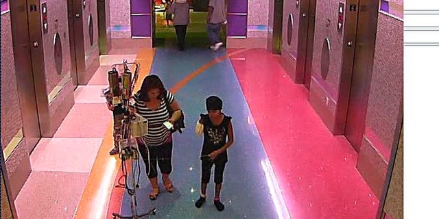 Dec. 3, 2012: In this hospital surveillance photo released by the Phoenix Police Department, a woman is seen with her 11-year-old daughter, a leukemia patient who had her arm amputated and a heart catheter inserted due to an infection.