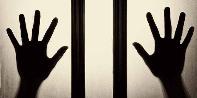 Female hand silhouette on the glass