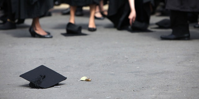 BIRMINGHAM, ENGLAND - JULY 14: Students pick up their mortarboards after the offical hat throwing photograph at the University of Birmingham on July 14, 2009 in Birmingham, England. Over 5000 graduates will be donning their robes this week to collect their degrees from The University of Birmingham. A recent survey suggested that there are 48 graduates competing for every job. (Photo by Christopher Furlong/Getty Images)